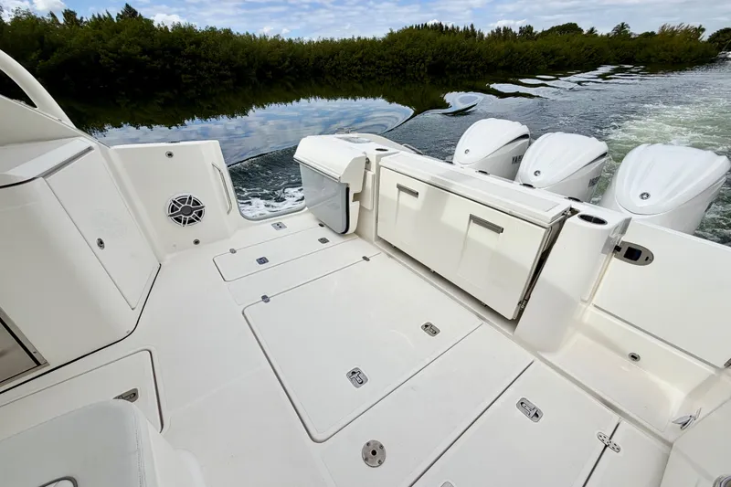 Slide: The Image of 2024 Pursuit DC 365 Dual Console boat with triple Yamaha engines on calm water. - 6