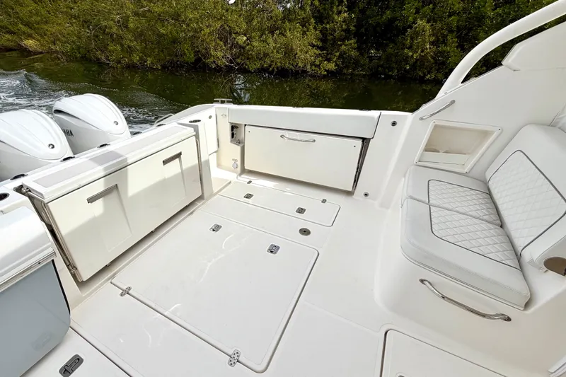 Slide: The Image of 2024 Pursuit DC 365 Dual Console boat interior with seating and storage compartments. - 8