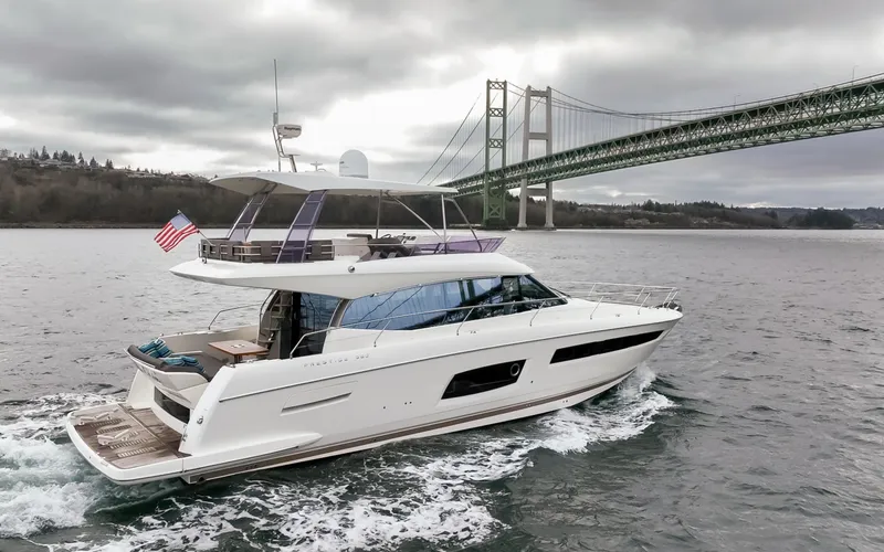 Slide: The Image of 2017 Prestige 560 yacht cruising near a large bridge on a cloudy day. - 44