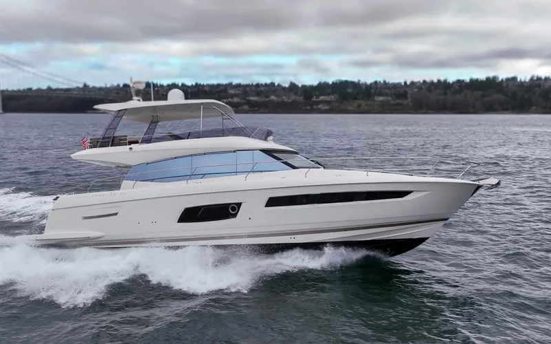 Slide: The Image of 2017 Prestige 560 yacht cruising on open water under cloudy skies. - 6