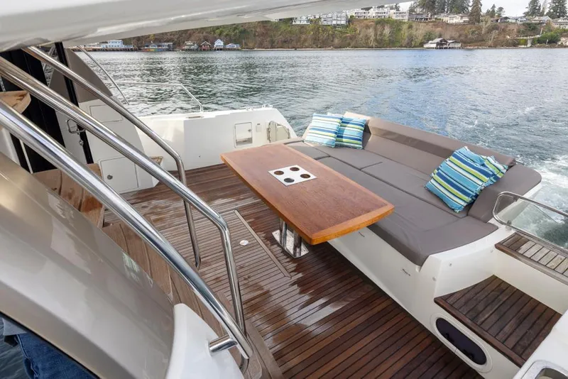 Slide: The Image of Prestige 560 yacht deck with seating and table, 2017 model, on calm water. - 8
