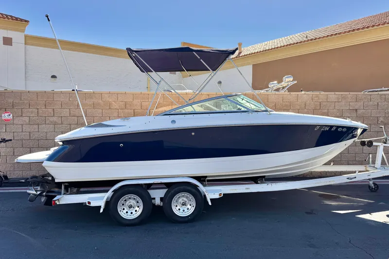 The Image of 2005 Cobalt 200 boat on trailer, parked outdoors, with blue and white exterior. - 0