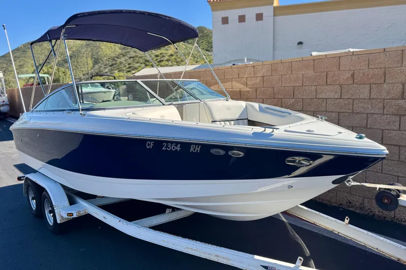 Slide: The Image of 2005 Cobalt 200 boat on trailer, blue and white, parked outdoors. - 1