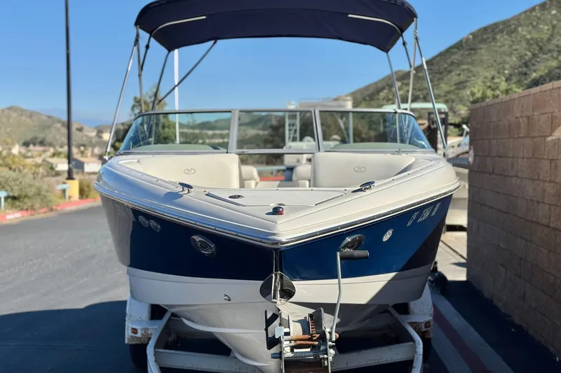 Slide: The Image of 2005 Cobalt 200 boat on trailer, blue and white, parked outdoors. - 2