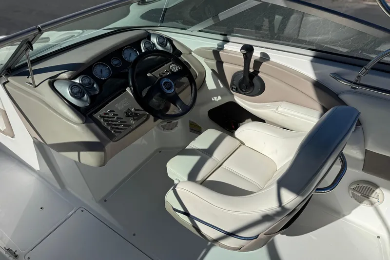 Slide: The Image of 2005 Cobalt 200 boat cockpit with steering wheel, gauges, and white seating. - 24