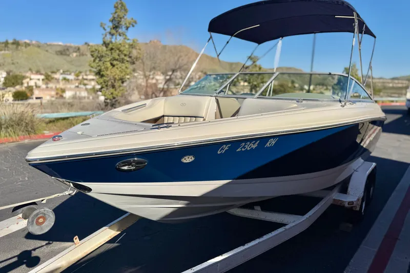 Slide: The Image of 2005 Cobalt 200 boat on trailer, blue and white, parked outdoors. - 3