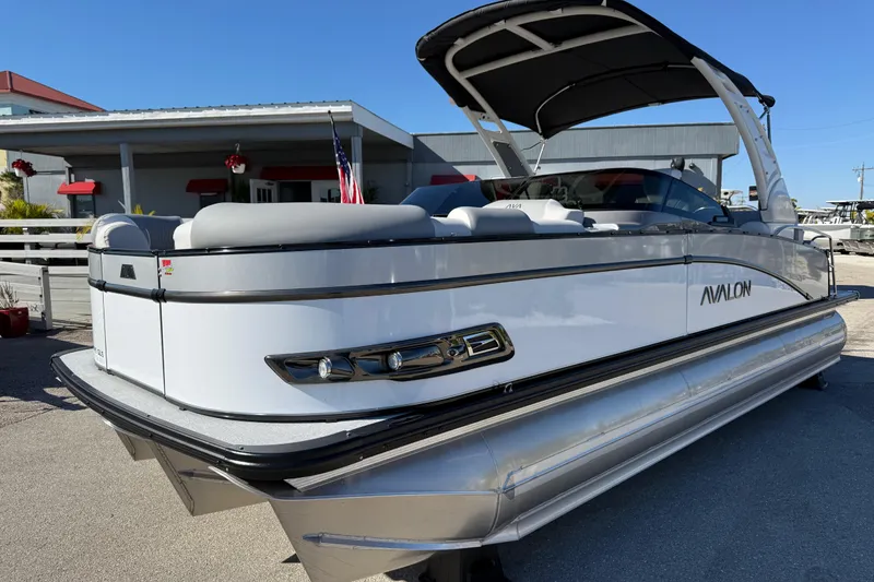 The Image of 2026 Avalon 2385 Catalina Windshield Quad Lounger, Tri Toon, high-performance boat in a marina setting. - 1