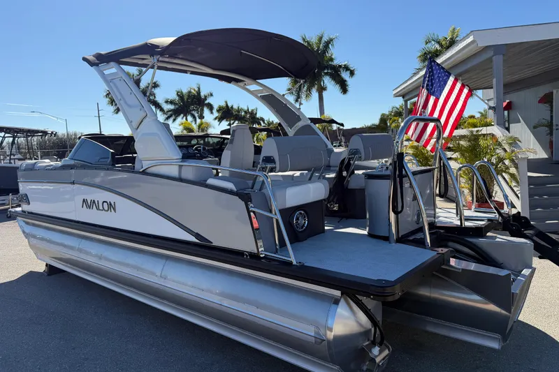 Slide: The Image of 2026 Avalon 2385 Catalina Windshield Quade Lounger Tri Toon boat with American flag displayed. - 10