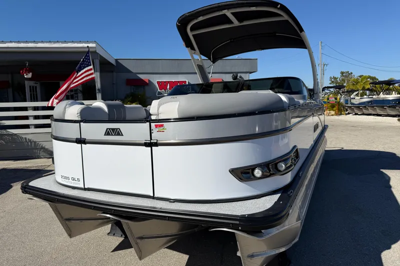 Slide: The Image of 2026 Avalon 2385 Catalina Windshield Quade Lounger Tri Toon boat, high performance, parked outdoors. - 3