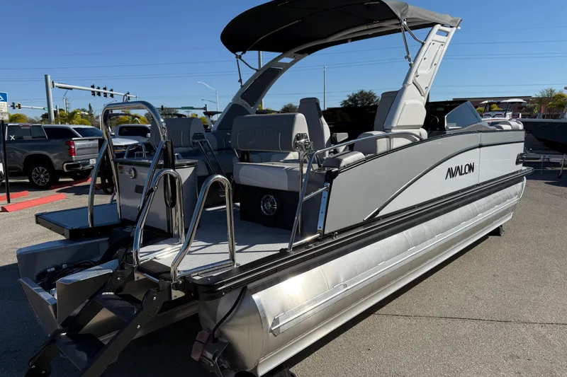 Slide: The Image of 2026 Avalon 2385 Catalina Windshield Quade Lounger, Tri Toon, High Performance boat in parking lot. - 7