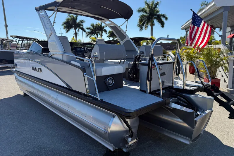 Slide: The Image of 2026 Avalon 2385 Catalina Windshield Quade Lounger Tri Toon boat with American flag, palm trees. - 9
