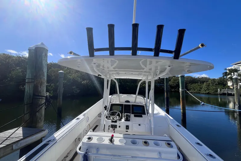 Slide: The Image of 2008 Intrepid 370 Cuddy boat interior with helm, docked by calm water. - 12
