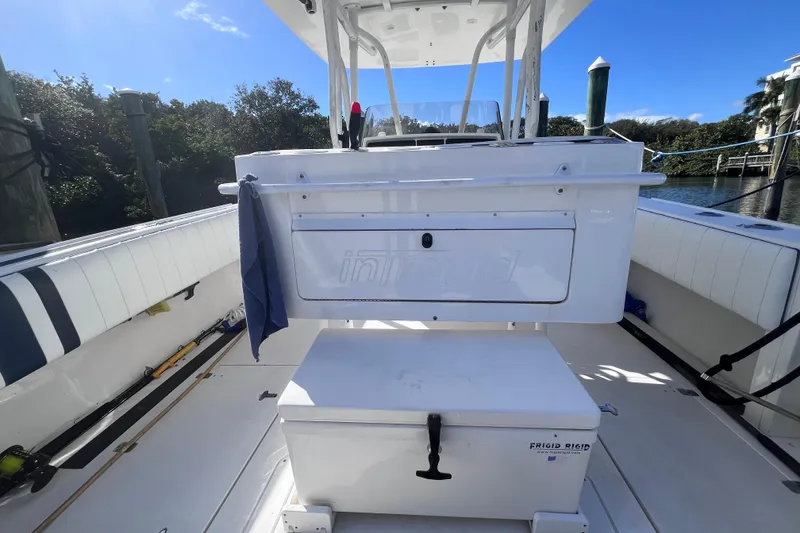 Slide: The Image of 2008 Intrepid 370 Cuddy boat interior with seating and speakers by the water. - 23