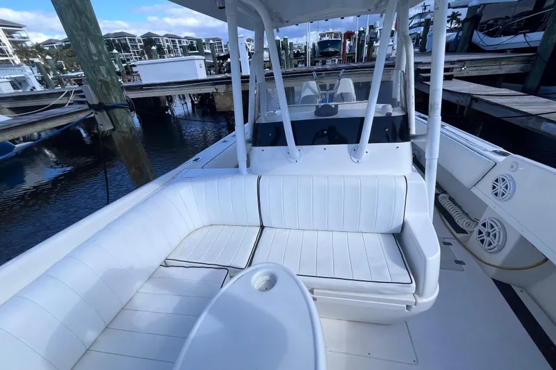 Slide: The Image of 2008 Intrepid 370 Cuddy boat interior with white seating and table, docked at marina. - 34