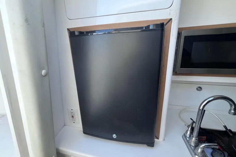 Slide: The Image of Microwave in 2008 Intrepid 370 Cuddy boat interior, featuring control panels and sink. - 45