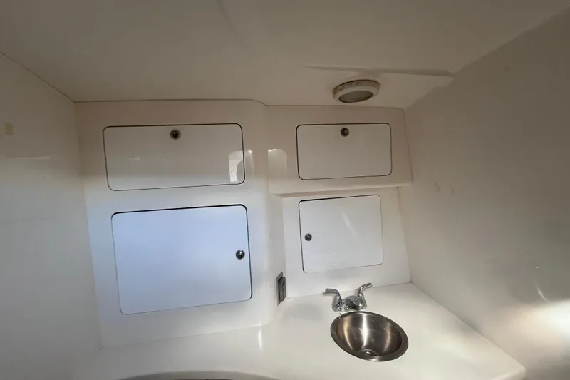 Slide: The Image of 2008 Intrepid 370 Cuddy boat bathroom with toilet, sink, and storage cabinets. - 48