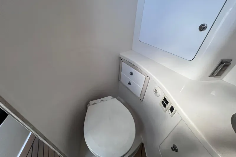 Slide: The Image of 2008 Intrepid 370 Cuddy interior with storage cabinets and a small sink. - 49