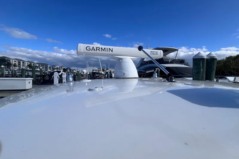 Slide: The Image of 2008 Intrepid 370 Cuddy boat with radar, docked under blue sky. - 55