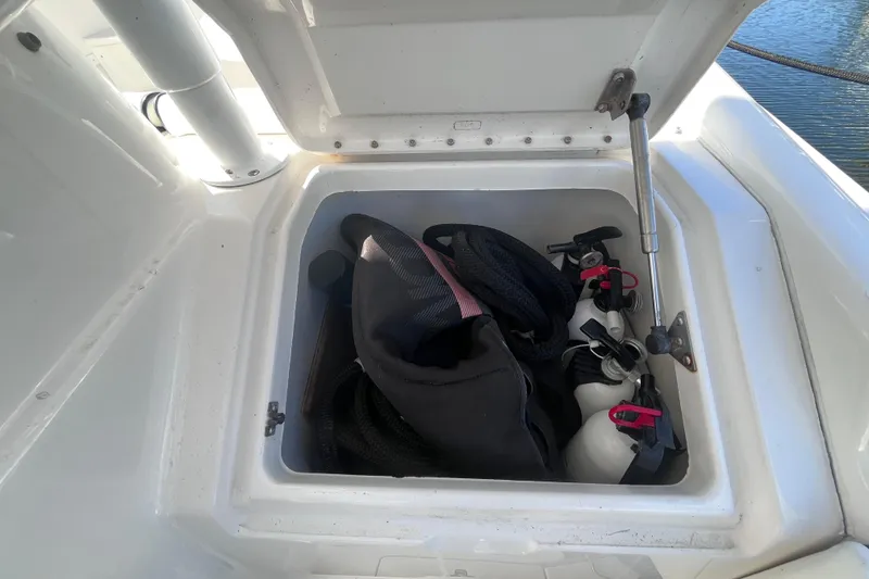 Slide: The Image of 2008 Intrepid 370 Cuddy boat interior with seating and speakers, docked by the water. - 67