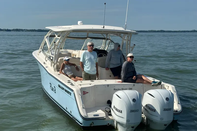 Slide: The Image of 2019 Grady-White Freedom 307 boat with passengers on calm water, featuring twin Yamaha engines. - 8