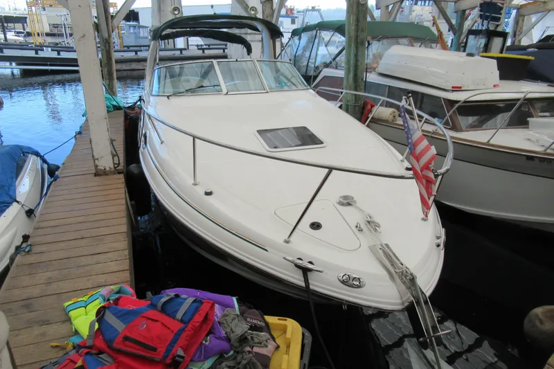 The Image of 2001 Searay 280 Sundancer docked, featuring sleek design and American flag. - 1
