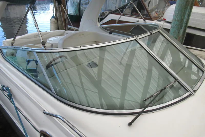 Slide: The Image of 2001 Searay 280 Sundancer boat with sleek windshield design, docked at marina. - 12