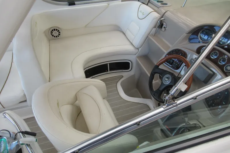 Slide: The Image of 2001 Searay 280 Sundancer boat interior with white seating and wooden steering wheel. - 14