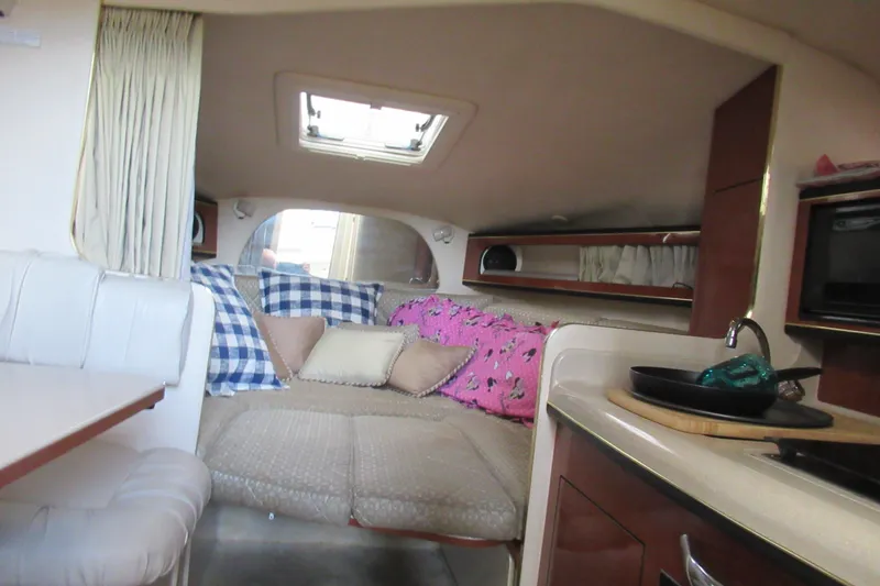 Slide: The Image of Interior of 2001 Searay 280 Sundancer boat with cozy seating and kitchenette. - 49