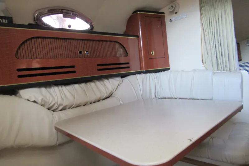 Slide: The Image of Interior of 2001 Searay 280 Sundancer with white seating and wooden cabinetry. - 50