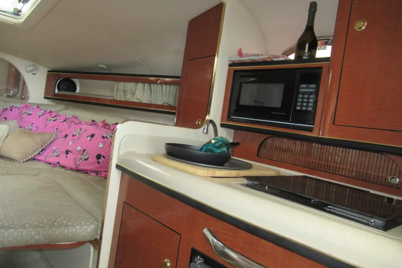 Slide: The Image of Interior of 2001 Searay 280 Sundancer boat with kitchenette and seating area. - 51