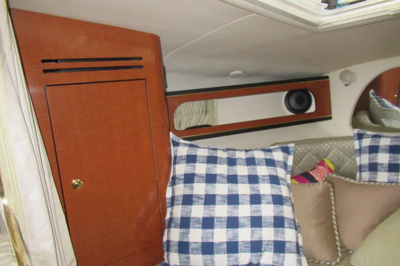 Slide: The Image of Interior of 2001 Searay 280 Sundancer with checkered pillows and wooden cabinetry. - 52