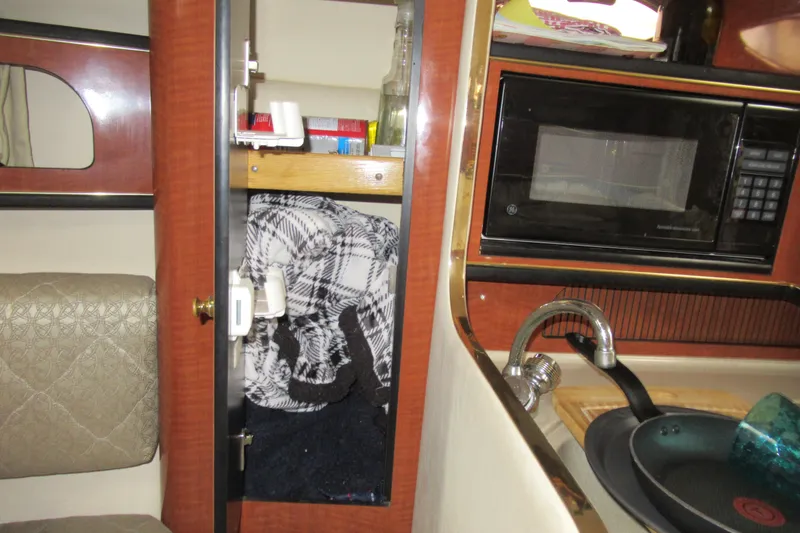 Slide: The Image of Interior of 2001 Searay 280 Sundancer with microwave, sink, and storage cabinet. - 55
