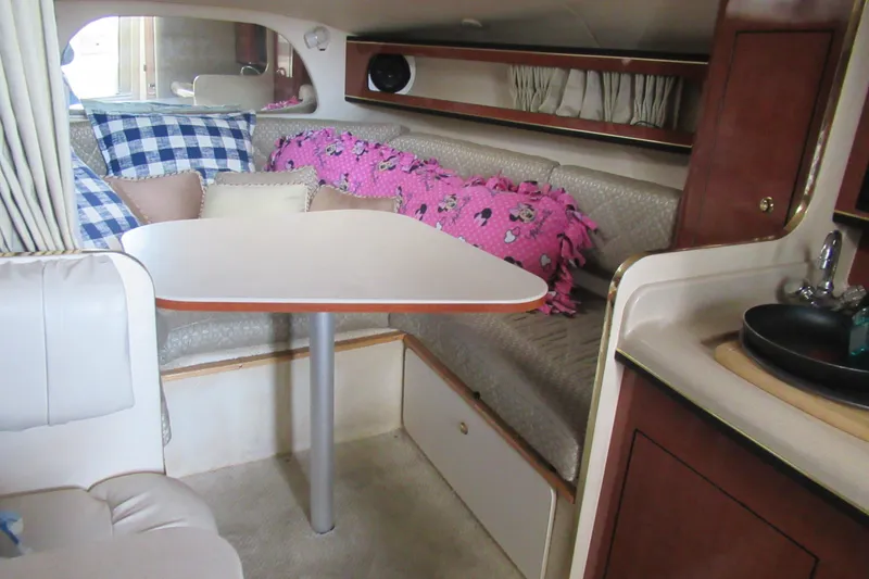 Slide: The Image of 2001 Searay 280 Sundancer cabin interior with dining area and colorful cushions. - 56