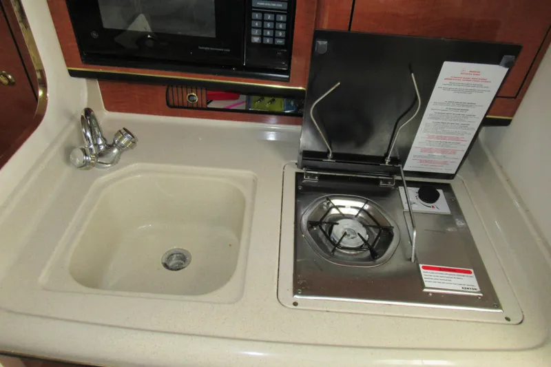 Slide: The Image of 2001 Searay 280 Sundancer galley with sink, stove, and microwave. - 59