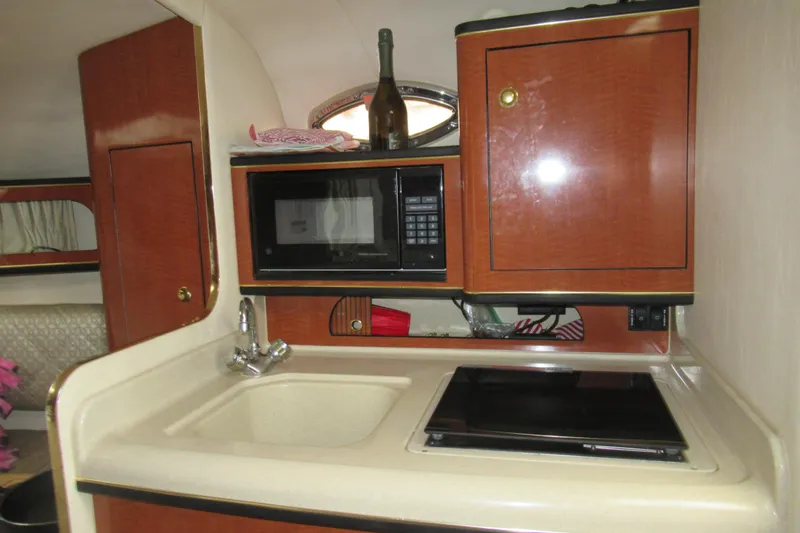 Slide: The Image of 2001 Searay 280 Sundancer kitchen with sink, microwave, and stove. - 62