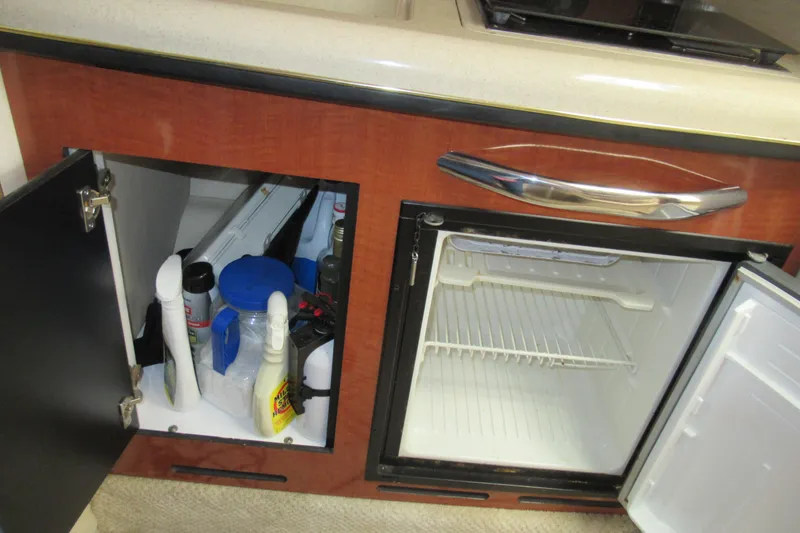 Slide: The Image of 2001 Searay 280 Sundancer interior with open cabinet and mini fridge. - 63