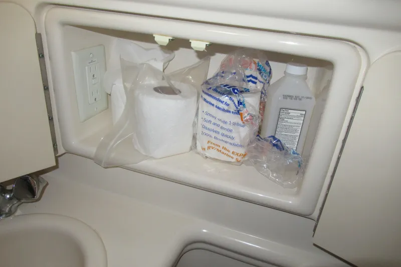 Slide: The Image of Storage compartment in 2001 Searay 280 Sundancer with toilet paper and cleaning supplies. - 65