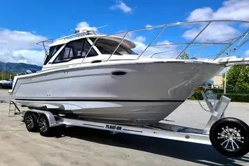 The Image of 2023 Cutwater C-248 Coupe boat on trailer, parked outdoors under blue sky. - 0