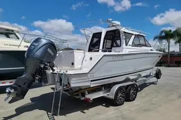 Slide: The Image of 2023 Cutwater C-248 Coupe boat on trailer, parked outdoors under blue sky. - 1