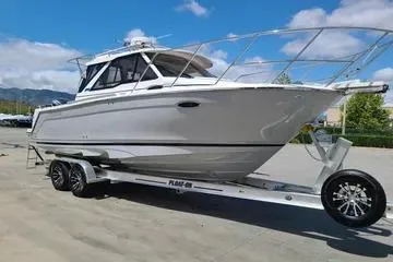 Slide: The Image of 2023 Cutwater C-248 Coupe boat on trailer, sleek design, clear sky background. - 2