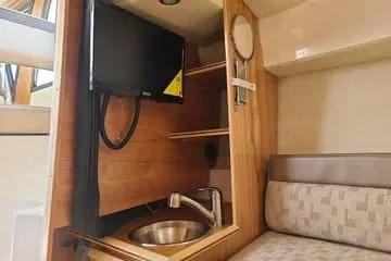 Slide: The Image of 2023 Cutwater C-248 Coupe interior with TV, sink, and seating area. - 5