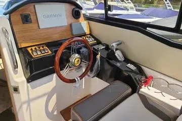 Slide: The Image of 2023 Cutwater C-248 Coupe cockpit with Garmin navigation, wooden accents, and modern controls. - 8