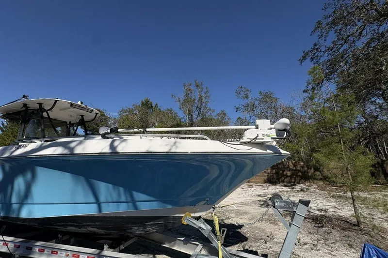 Slide: The Image of 2008 Wellcraft 35 Scarab Sport boat on trailer, surrounded by trees under clear blue sky. - 106
