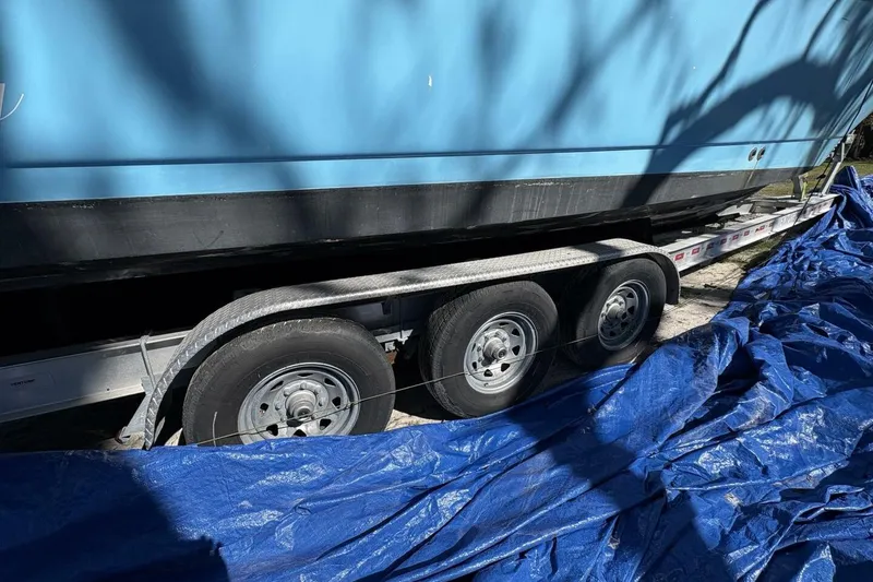 Slide: The Image of 2008 Wellcraft 35 Scarab Sport boat on trailer, partially covered with blue tarp. - 107