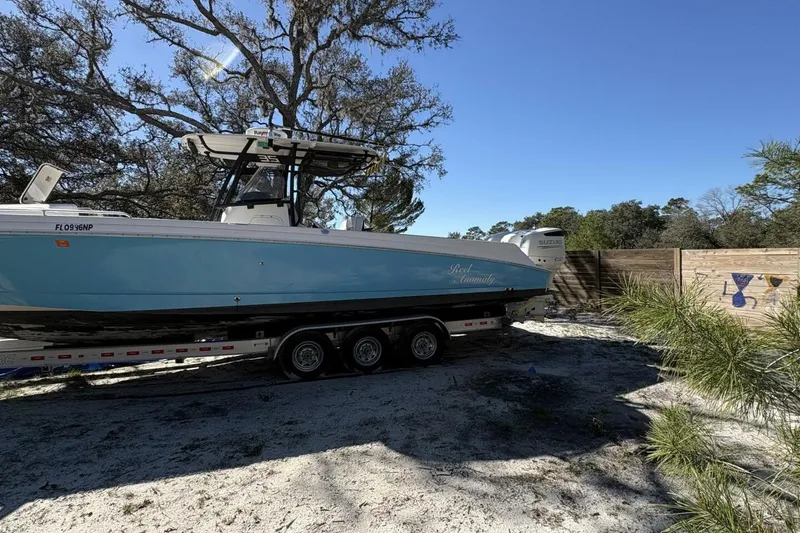 Slide: The Image of 2008 Wellcraft 35 Scarab Sport boat on trailer, parked outdoors under clear blue sky. - 114