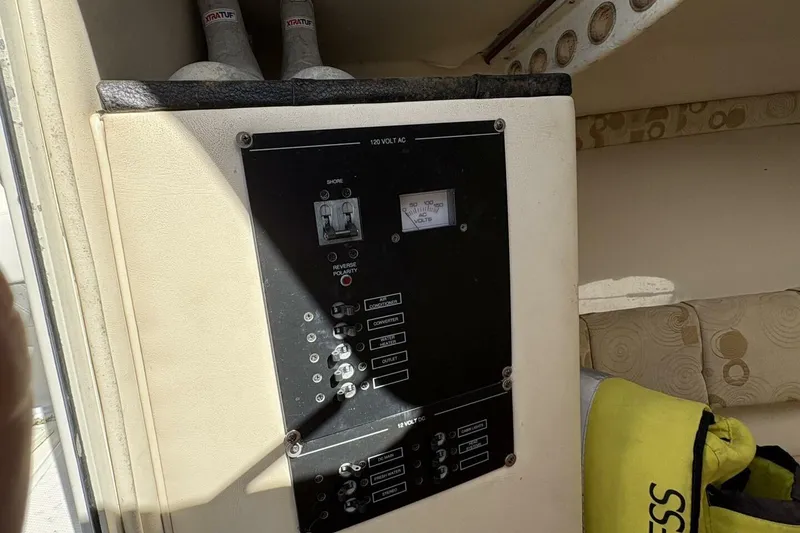 Slide: The Image of Electrical panel inside 2008 Wellcraft 35 Scarab Sport boat cabin, featuring various switches and controls. - 19