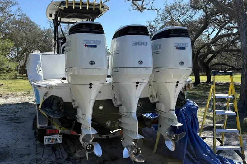 Slide: The Image of 2008 Wellcraft 35 Scarab Sport with triple Suzuki 300 outboard engines, parked outdoors. - 2