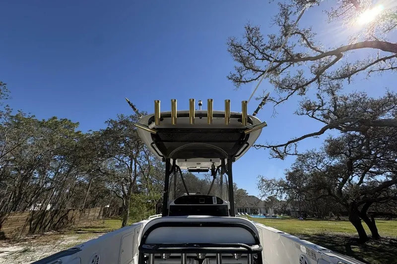 Slide: The Image of 2008 Wellcraft 35 Scarab Sport boat under clear blue sky with trees in the background. - 55
