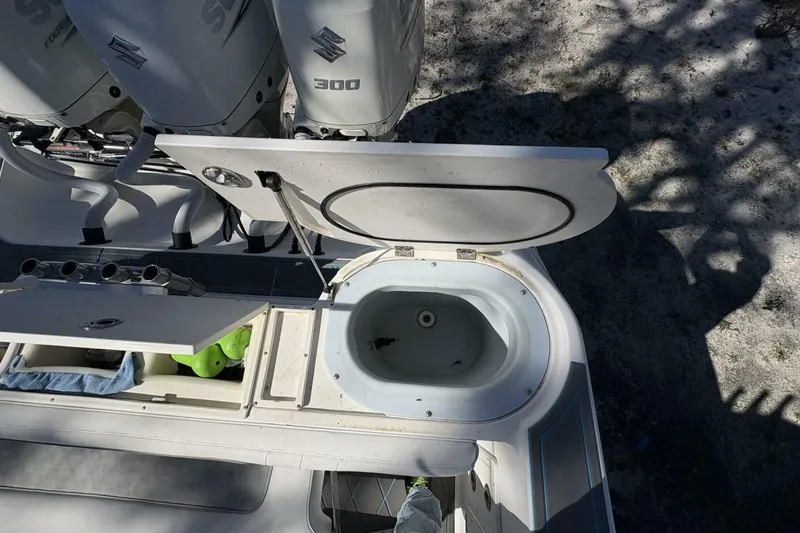 Slide: The Image of 2008 Wellcraft 35 Scarab Sport boat with open storage compartment and Suzuki 300 engines. - 64