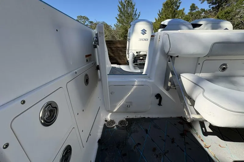 Slide: The Image of 2008 Wellcraft 35 Scarab Sport boat interior with Suzuki 300 engines, white seating, and storage compartments. - 84